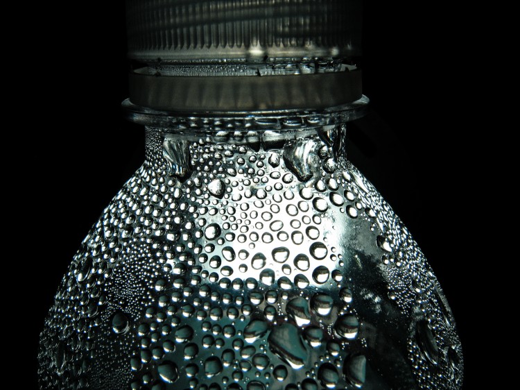 Makro fotka orosené pet lahve s vodou na černém pozadí