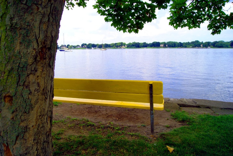 Žlutá lavička na břehu řeky