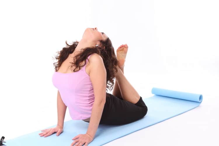 Žena cvičí jógu na světle modré podložce