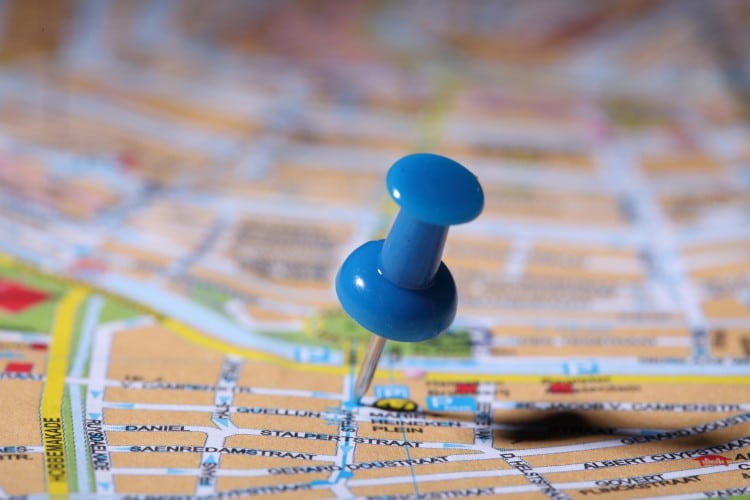 Modrý napínáček zapíchnutý do mapy města